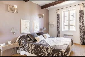 a bedroom with a bed and a desk and a window at Douceur sur la Sorgue in LʼIsle-sur-la-Sorgue