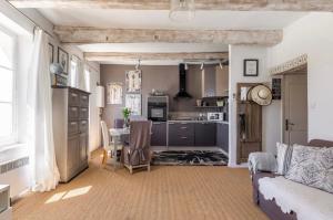 a kitchen and living room with a couch and a table at Douceur sur la Sorgue in LʼIsle-sur-la-Sorgue