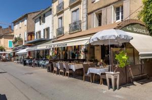 un ristorante all'aperto con tavoli, sedie e ombrelloni di Douceur sur la Sorgue a LʼIsle-sur-la-Sorgue