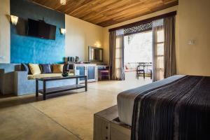 a hotel room with a bed and a living room at Yasmin Hill Longevity Oasis in Kandy