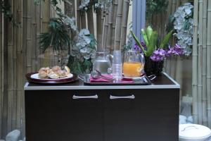 a table with a plate of food and drinks on it at Catone District Hotel in Rome
