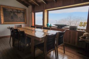 a dining room with a table and chairs and a large window at Loma del Viento in Farellones