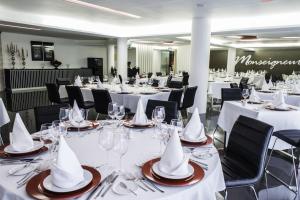 a group of tables with white tablecloths and napkins at Hotel Vip Praia in Praia