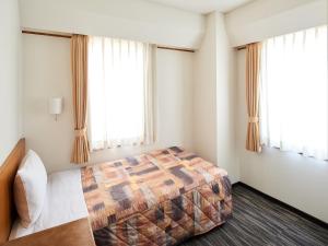 a bedroom with a bed and two windows at Marroad Inn Akasaka in Tokyo