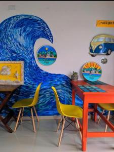 a room with a painting of a wave on the wall at Maresia Hostel Paraty BR in Paraty