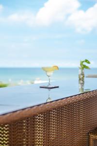 una copa de vino en un balcón con vistas al océano en The Palms Resort & Bar, en San Narciso