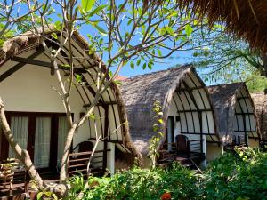 a house with chairs in front of it at The Yoga Garden in Gili Trawangan