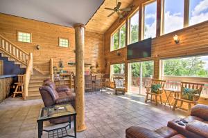 a large living room with leather furniture and windows at Spacious Frazee Home with Direct Lake Access! in Frazee