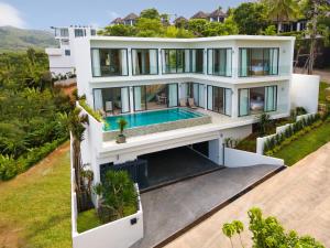 eine Luftansicht auf ein weißes Haus mit einem Pool in der Unterkunft Areeya Villa Layan Phuket in Phuket