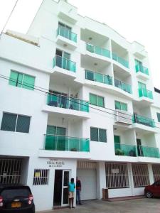Bonito apartamento en Cartagena con garaje gratuito في كارتاهينا دي اندياس: شخصين واقفين أمام مبنى أبيض