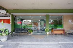 Urbanview Hotel Capital Makassar في Pampang: لوبي فيه كراسي وطاولات في مبنى