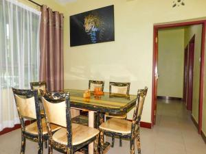 ein Esszimmer mit einem Glastisch und Stühlen in der Unterkunft Luxurious 3 bedroom Furnished Apartment R1 in Shanzu