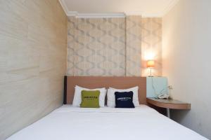 Tempat tidur dalam kamar di Urbanview Hotel Capital Makassar