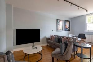 a living room with a couch and a flat screen tv at Luxurious Private One Bedroom Apartment in Braintree