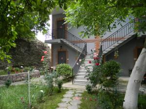 a house with stairs and flowers in the yard at Hotel Beni in Akhaltsikhe