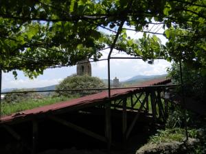 an old wooden bridge with a tower in the distance at Hotel Beni in Akhaltsikhe