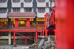 um edifício com uma ponte vermelha em frente a um edifício em Seitenkaku em Hita