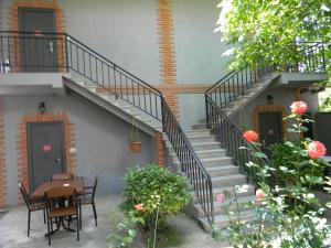 a staircase leading up to a house with a table and chairs at Hotel Beni in Akhaltsikhe