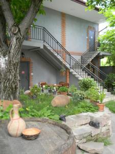 a house with a tree and some vases in the yard at Hotel Beni in Akhaltsikhe