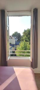 a bedroom with a large window with a view at Histoire de Loire - ANJOU sdb partagée in Saumur