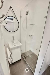 a bathroom with a shower and a sink and a mirror at Tea Gardens Hotel in Tea Gardens