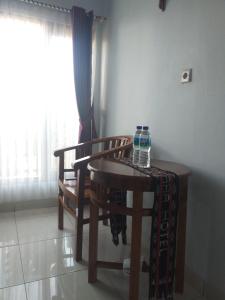a table and two chairs with a bottle of water on it at Hotel Mehara in Labuan Bajo