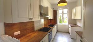 une cuisine avec des armoires blanches et un four à plaques de cuisson dans l'établissement Histoire de Loire - ANJOU sdb partagée, à Saumur 16 autres photos