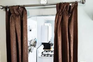 a kitchen with brown curtains and a stove at Private Studio- Queen Bed- 10 min to DT Indy in Indianapolis
