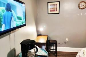 a living room with a flat screen tv on a wall at Private Studio- Queen Bed- 10 min to DT Indy in Indianapolis