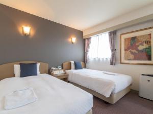 Postel nebo postele na pokoji v ubytování Nagasaki Orion Hotel