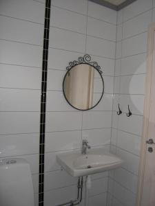 W białej łazience znajduje się umywalka i lustro. w obiekcie B & B Flattinge Fritidshus w mieście Vittaryd