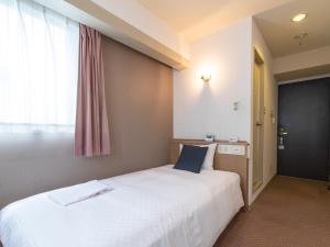 Un dormitorio con una gran cama blanca y una ventana en Nagasaki Orion Hotel, en Nagasaki