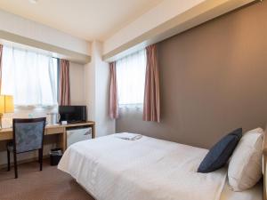 una camera d'albergo con letto e scrivania di Nagasaki Orion Hotel a Nagasaki
