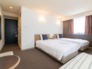 Postel nebo postele na pokoji v ubytování Nagasaki Orion Hotel