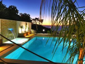 - une piscine avec vue sur l'océan la nuit dans l'établissement Casa Oleandri, à Tresnuraghes