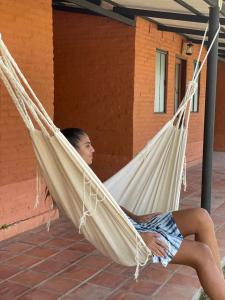 a woman is sitting in a hammock at La Matilde Lodge in San Bernardino