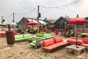 een zithoek met kleurrijke stoelen en parasols bij Piet's Beachhouse in Katwijk aan Zee