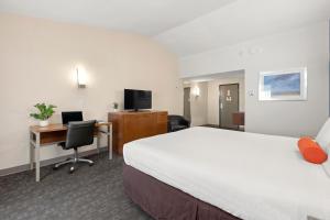 Good Nite Inn Redwood City - San Francisco Airport في ريدوود سيتي: غرفة الفندق بسرير كبير ومكتب