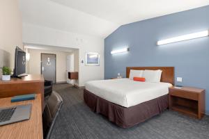 レッドウッドシティにあるGood Nite Inn Redwood City - San Francisco Airportのベッドとデスクが備わるホテルルームです。