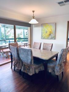 a dining room with a wooden table and chairs at Gorgeous house near beach with nature view in Frankston