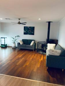 a living room with two chairs and a couch at Gorgeous house near beach with nature view in Frankston