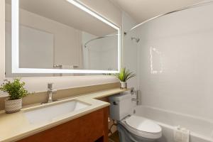 uma casa de banho com um lavatório, um WC e um espelho. em Good Nite Inn Fremont em Fremont