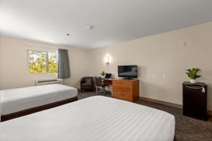 a hotel room with two beds and a desk at Good Nite Inn Fremont in Fremont