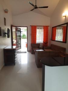 uma sala de estar com um sofá e uma ventoinha de tecto em Vila Romila em Cavelossim