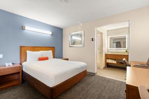 a hotel room with a bed and a bathroom at Good Nite Inn Fremont in Fremont