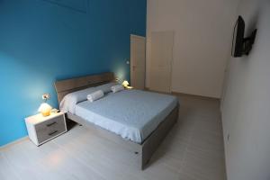 - une chambre avec un lit et un mur bleu dans l'établissement casa Elodie, à Naples