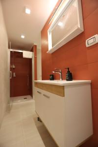 La salle de bains est pourvue d'un lavabo et d'une douche. dans l'établissement casa Elodie, à Naples