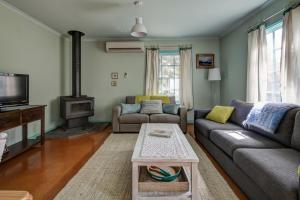a living room with a couch and a tv at Prues Cottage in Port Fairy