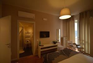 Un dormitorio con una cama, un escritorio y un televisor. en B&B Room Italy, en Bérgamo