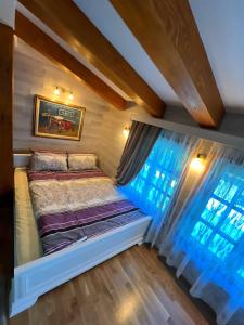 a bed in a tiny house with a window at Apartmani Vila Vjerra in Žabljak